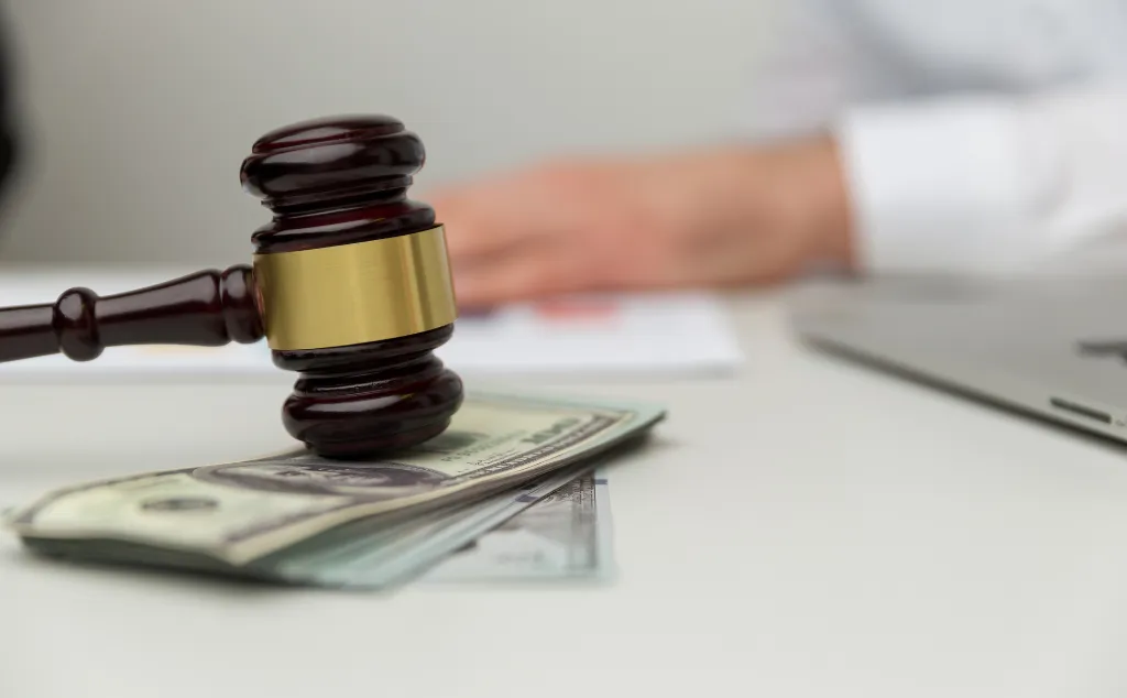 Legal alimony concept. Closeup view of wooden gavel and money.