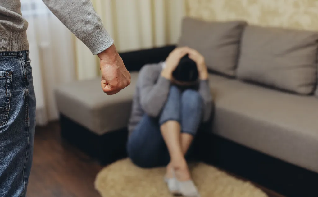 The alcoholic husband beats his wife with his fist. Zhenzhina covers herself with her hands. Violence in family
