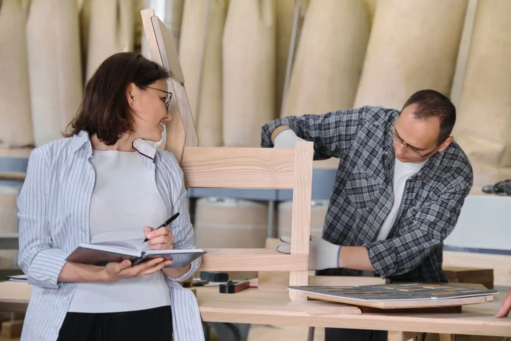 An image of a man and a woman working together on assembling or repairing furniture.