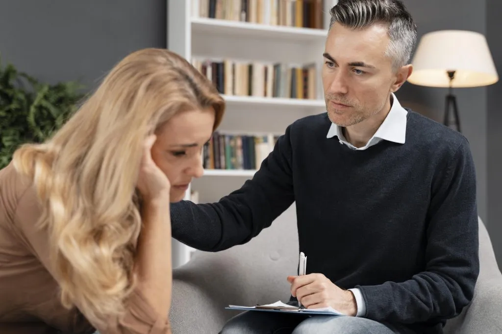 An image of a sad girl being comforted by a man.