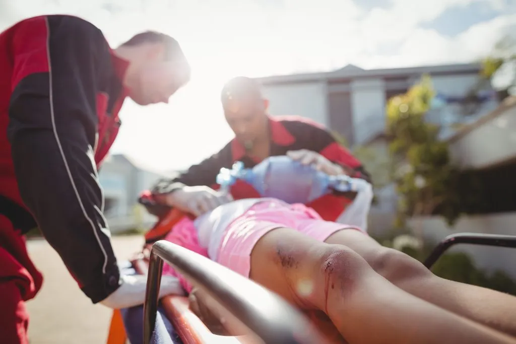An image of a paramedic administering oxygen to an injured man.