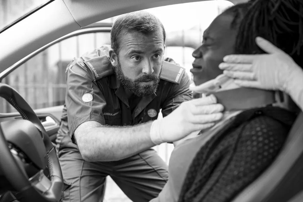 Paramedic placing cervical collar to an injured woman